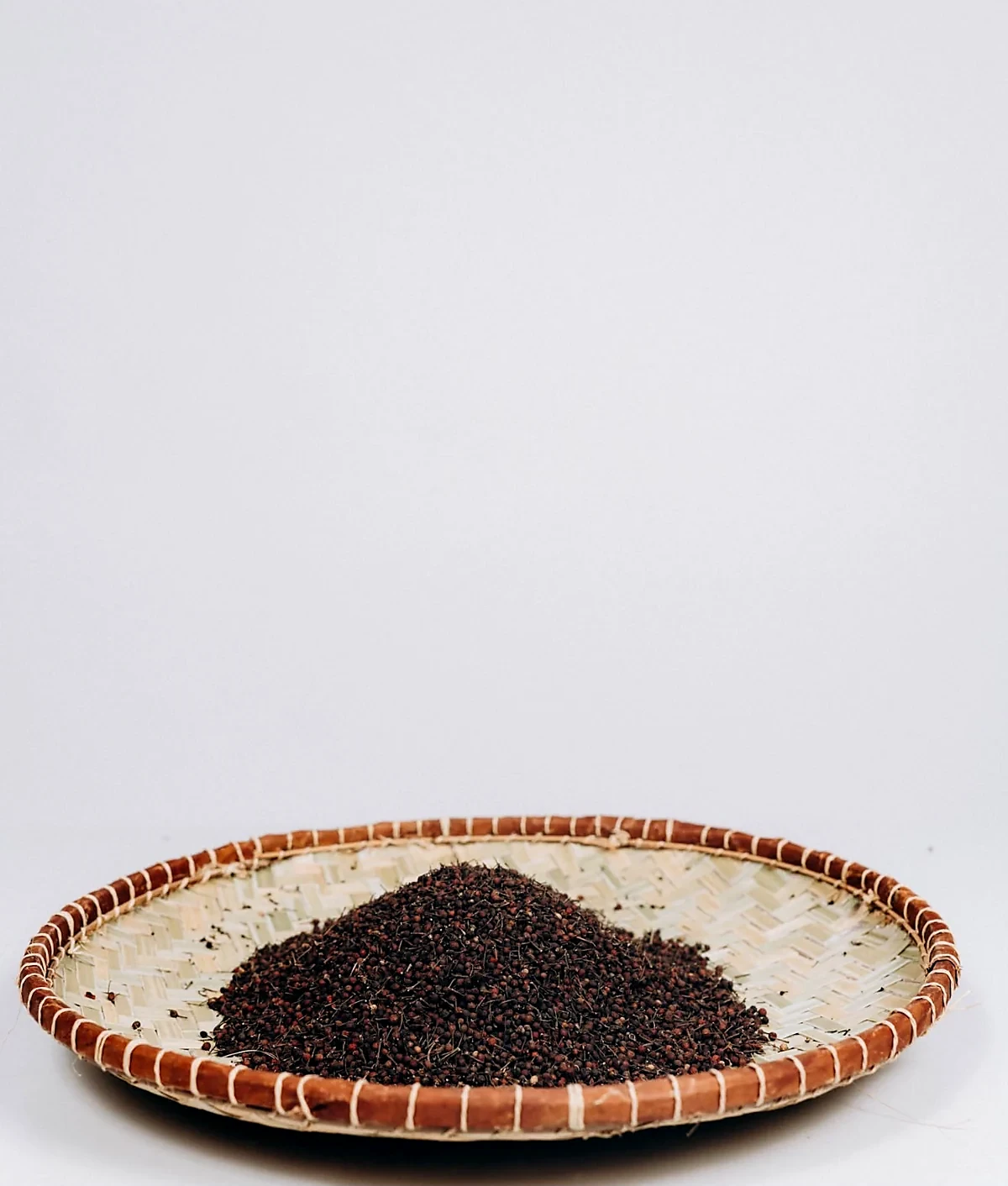 Grains de poivre présentés dans une coupelle tressée